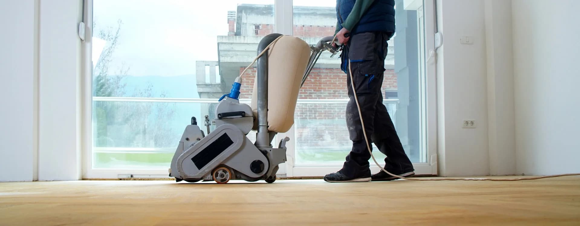 Een parketteur met een vloermachine in Assendelft.